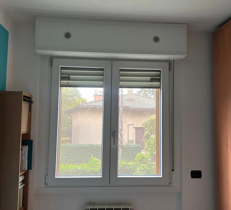 Finestra in PVC bianco con cassonetto, in una cameretta.